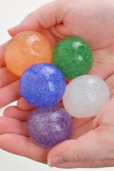 three different colored balls in the palm of someone's hand with their fingers on them