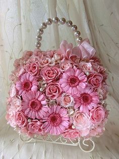 a pink purse with flowers and pearls on it