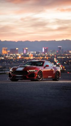 a red sports car parked in front of a city