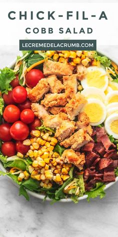 a large salad with hard boiled eggs, corn, tomatoes and lettuce in it