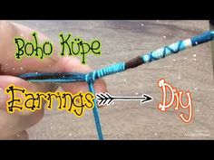 someone crocheting the end of a rope with blue and green yarn on it