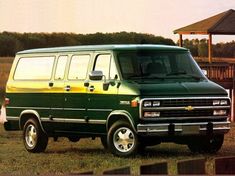 a green and yellow van is parked in the grass