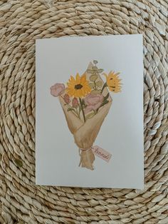 a card with flowers on it sitting on top of a wicker basket