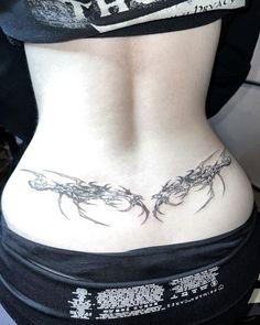 a woman's lower back tattoo with vines on it