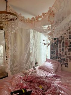 an unmade bed in a bedroom with pink comforter and white drapes hanging from the ceiling