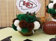 two footballs are sitting on a table next to some flowers and other decorations,