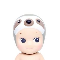 a baby doll with big eyes and a white cap on it's head, sitting in front of a white background