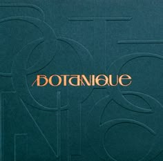 the logo for botanique is shown in gold on a dark green paper background