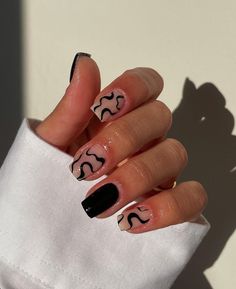 a woman's hand with black and white nail polish