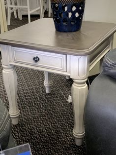 a white table with a blue basket on top