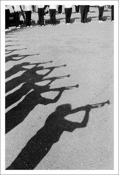 a group of people standing next to each other with their shadows on the ground in front of them