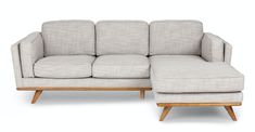 a white couch with a wooden frame and footstool on the bottom right side