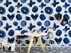 two chairs and a table in front of a wall with blue circles on it