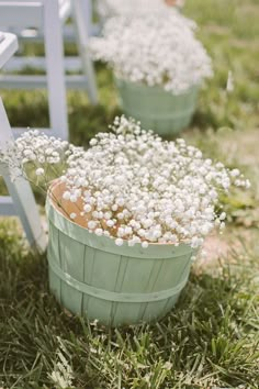 two buckets filled with baby's breath sitting on top of grass next to each other