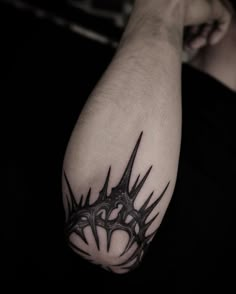 a black and white photo of a man's arm with an intricate tattoo design on it