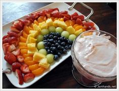 a platter filled with fruit and dip