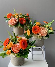 three vases filled with flowers on top of a white table