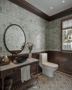 a bathroom with wood paneling and tile flooring, along with a round mirror on the wall