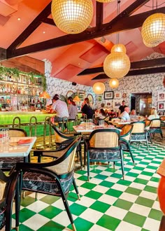 people sitting at tables in a restaurant with green and white checkered flooring