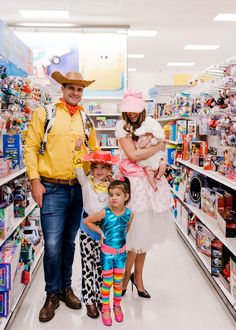 a man, woman and two children in a toy store aisle