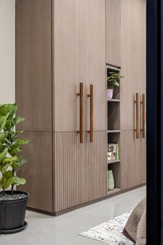 a bedroom with a bed, plant and cupboards