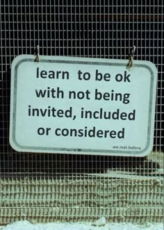 a sign that is attached to a fence with some kind of writing on it,