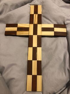 a wooden cross sitting on top of a bed