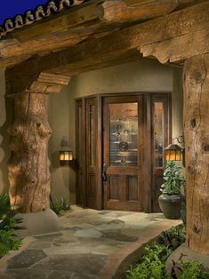 an image of a front door and entry way with the caption'i love several elements of this entryway - the tree trunk pillars, the path, the path and