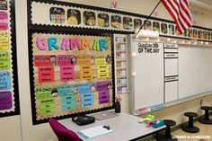 a classroom with desks, chairs and bulletin boards on the wall in front of them