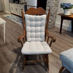 a wooden rocking chair sitting in a living room