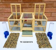 a bird cage with two birds in it and three smaller cages next to each other