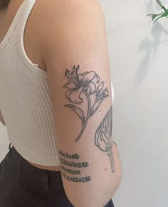 a woman with a flower tattoo on her left arm and right arm behind her back