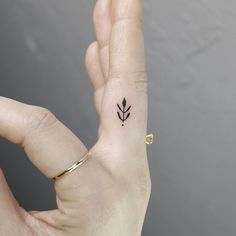 a woman's hand with a small tattoo on it, showing the middle finger