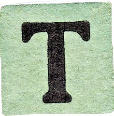 the letter t is made out of green paper with black letters on it, and there is