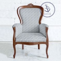 a white and brown striped chair sitting in front of a brick wall