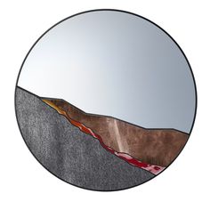 a circular mirror with an image of mountains in it