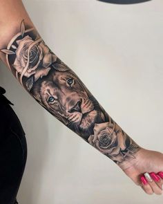 a woman's arm with a lion and roses tattoo on it