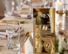 a table set for a formal dinner with menus and glasses on it, along with place settings