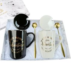 two coffee mugs in a gift box with spoons