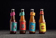 four beer bottles with different colored labels on them