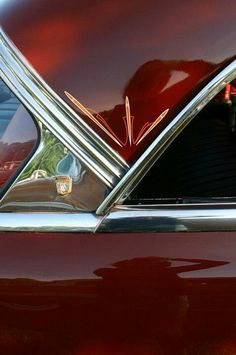 the back end of a classic car with its hood up