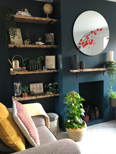 a living room filled with lots of plants next to a fire place and a mirror