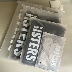 three packets of sleep systems sitting on top of a counter next to a cup and saucer