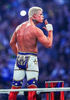 the wrestler is standing on top of two red and blue stools