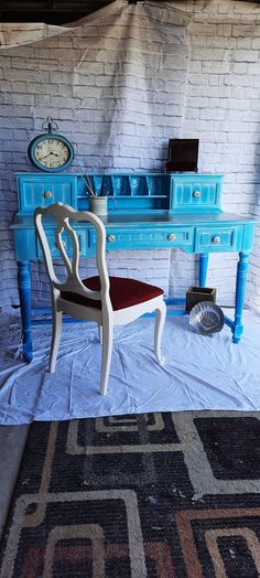 a blue desk with a chair in front of it