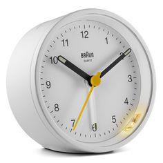 a white alarm clock with yellow hands and numbers on the face is shown in front of a white background