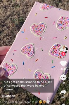 someone holding up a pink box with sprinkles and hearts cut out of it