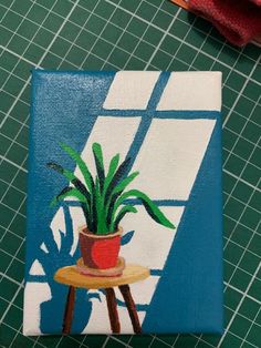 a potted plant sitting on top of a wooden table next to a red towel