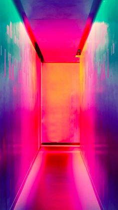 an empty room with bright colored walls and flooring in the center is lit by neon lights