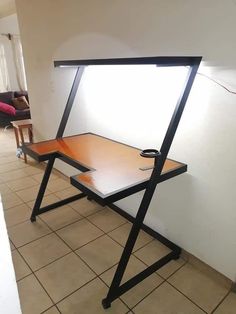 a table with a laptop on it in the middle of a room that has tile flooring